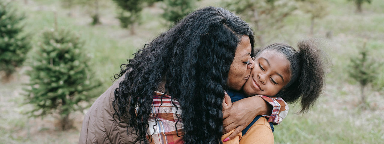 Woman kissing young girl in Cypress | Dry Eye And Myopia Management at Cypress Vision Therapy