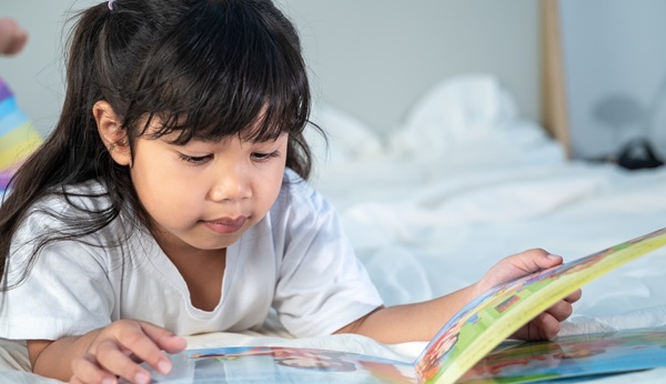 girl sleeping and reading fairy tales on white bed in bedroom (2)